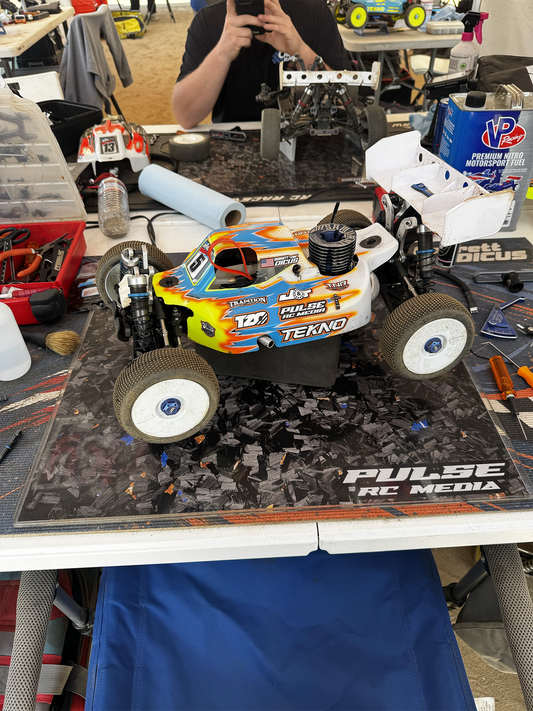 Yellow and blue RC buggy on a custom pit board at a race pit table