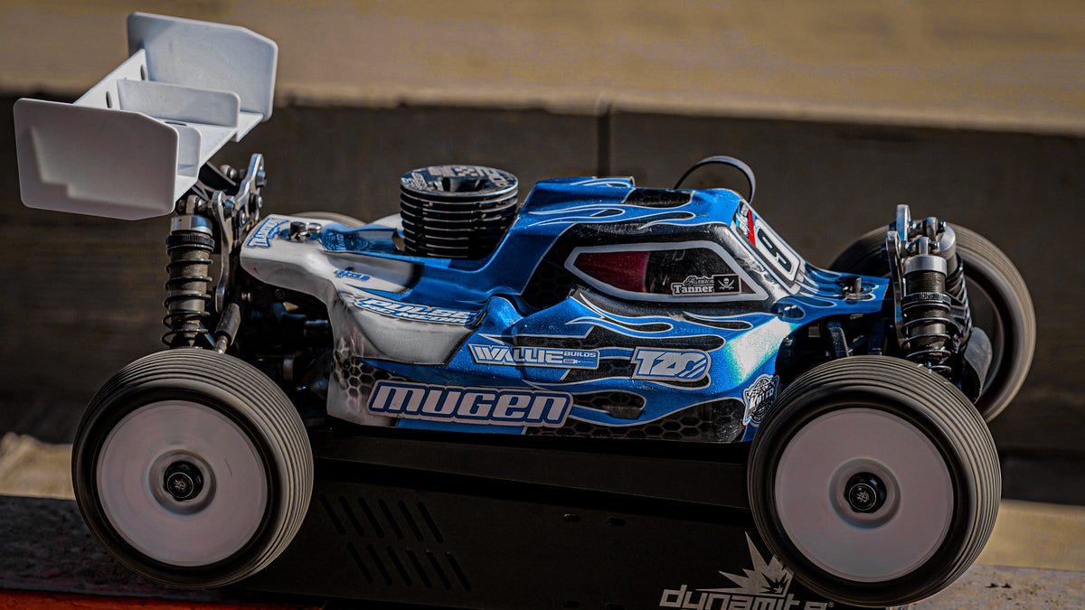 Side view of a blue RC buggy with body graphics